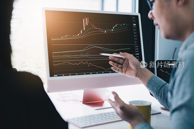 业务团队一起分析技术价格图表和指标。图表和股票交易电脑屏幕。