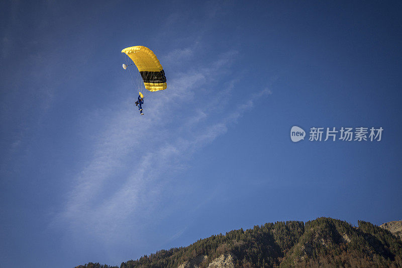 在空中飞行中，滑翔伞在晴朗的天空中滑翔