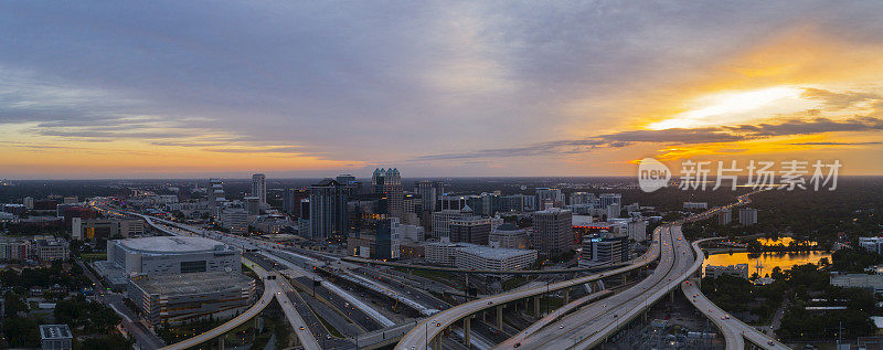 宽广的空中全景，奥兰多市中心的巨大交通枢纽与高速公路，多个天桥在清晨日出。超大，高分辨率的拼接全景图。