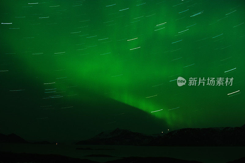 绿色的北极光在夜空和星星的轨迹