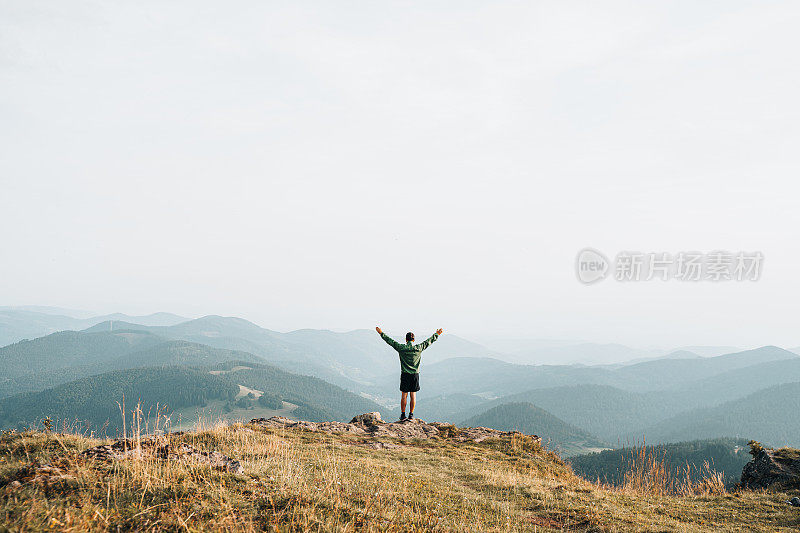 徒步旅行者在长满草的山脊上放松的观点