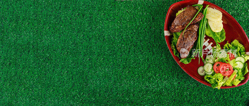 美式足球的横幅。盘子里有牛排和沙拉。