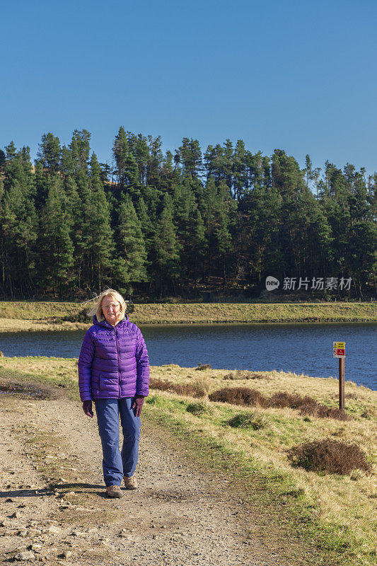 在英格兰兰开夏郡克利西罗附近的一条乡间小道上，一名孤独而活跃的老年女性走向镜头。