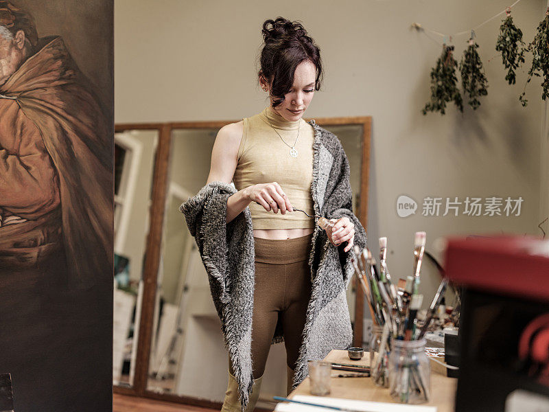 年轻的白人女性艺术家在她的工作室绘画