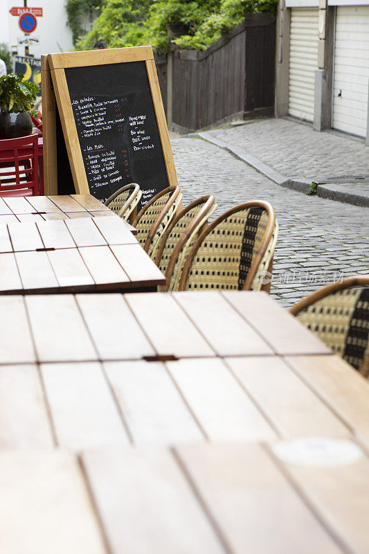 巴黎一家咖啡馆外的咖啡桌椅上有黑板菜单