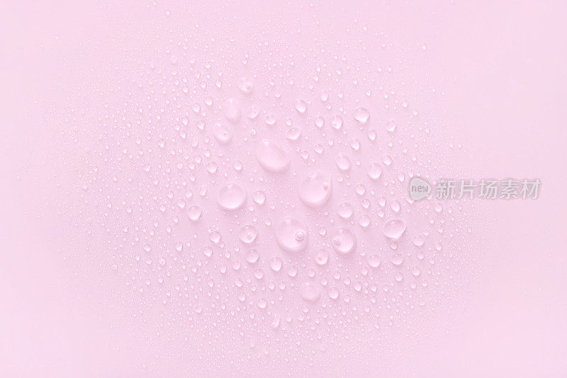 水滴在淡粉色的背景上