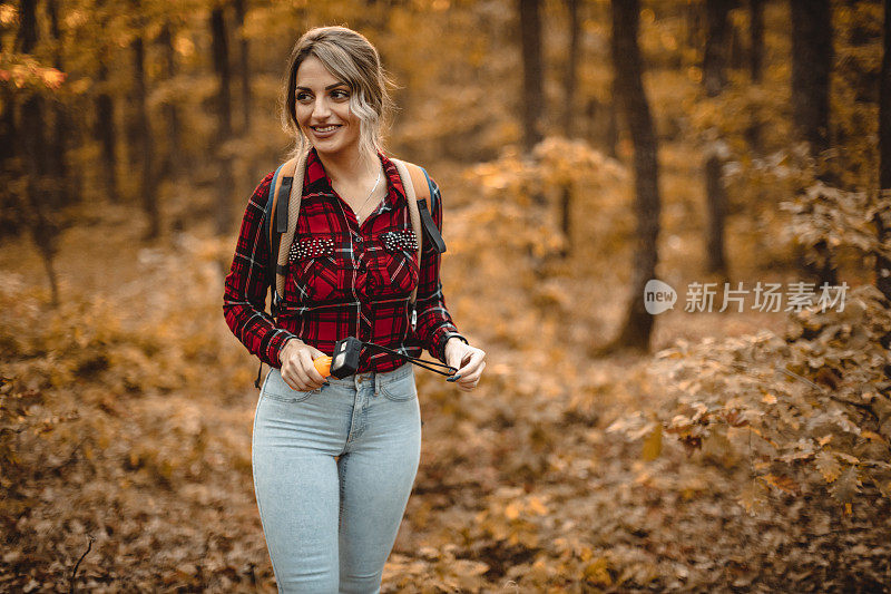 女人带着动作相机探索秋天的森林