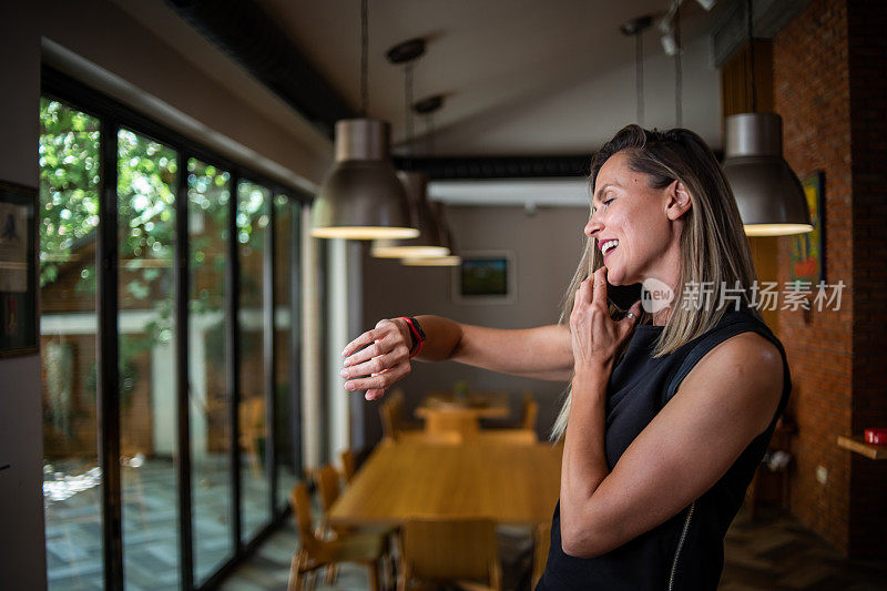 一位女商人站在餐厅里用手机