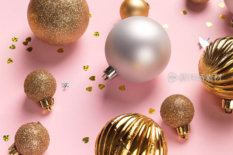 粉红色背景的金色和银色球的圣诞卡片