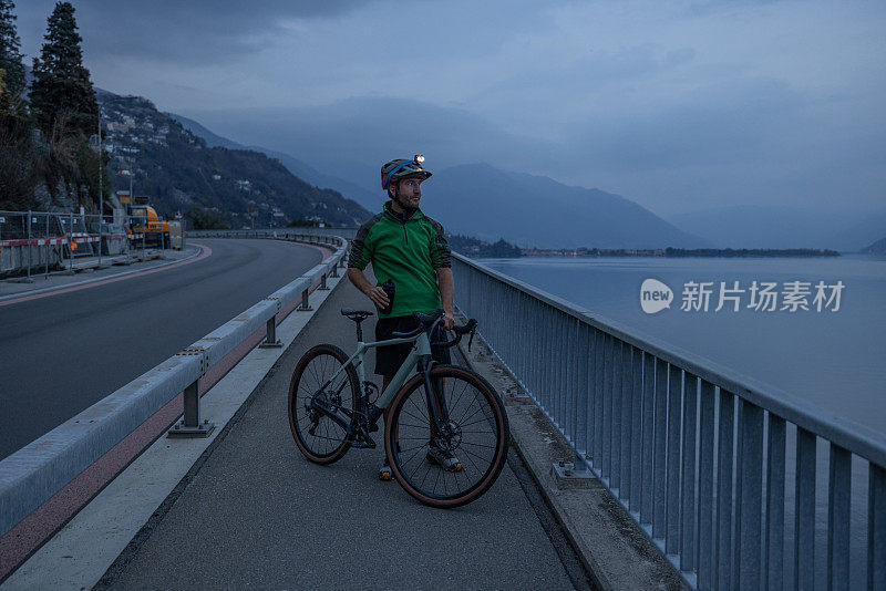 晚上骑自行车训练的男子在自行车道上休息