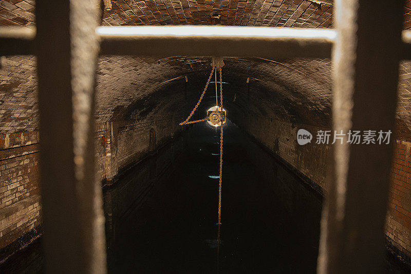 金属链悬挂在地下旧污水处理厂隧道的天花板上