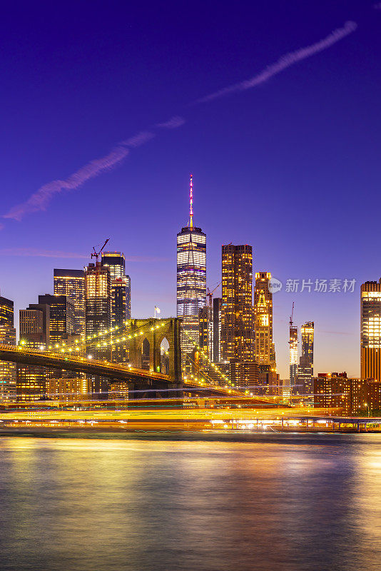 布鲁克林大桥、世界贸易中心一号大楼、曼哈顿市中心和夜间摩天大楼的全景。