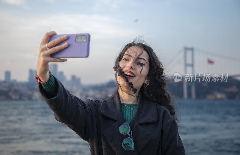 美丽的年轻黑发女子与眼镜在博斯普鲁斯在白天自拍