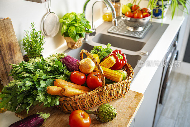 厨房柜台上装满新鲜蔬菜的篮子