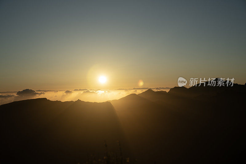 落日映衬下山峰的剪影