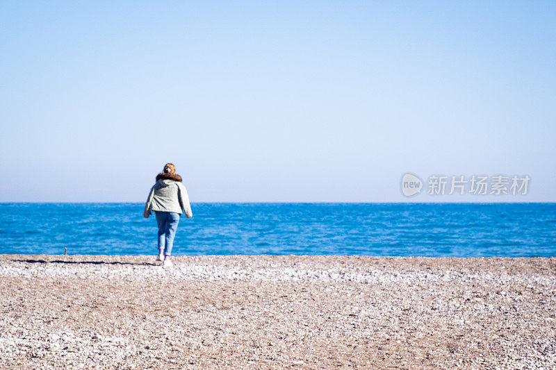 一位年轻女子走向地中海无边无际的蔚蓝