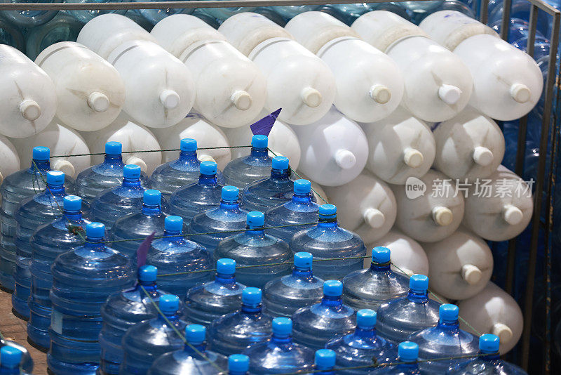 大的白色和蓝色容器库存的饮用水在一个仓库的水制造。