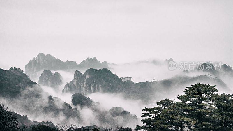 中国黄山国家公园，远处雾气缭绕的群山