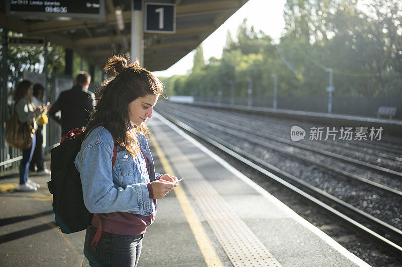火车进站时，年轻女子站在火车站。