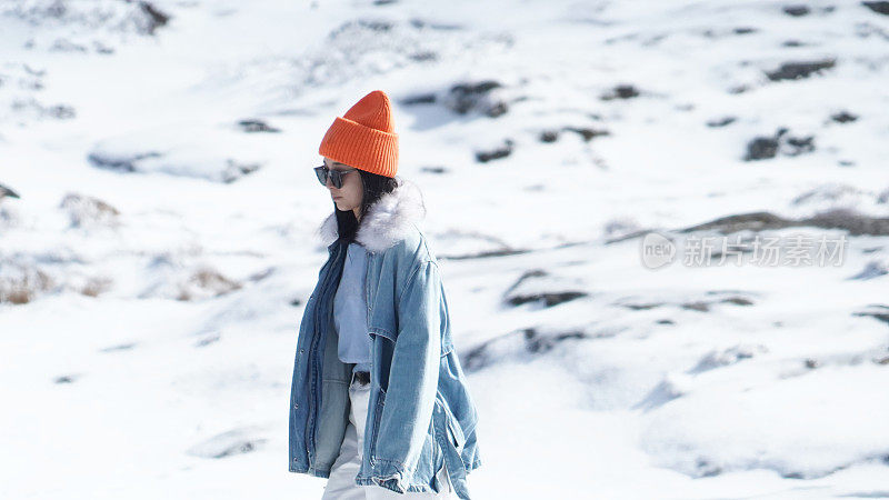 一个女人在寒冷的天气里穿行于白雪覆盖的山林之中