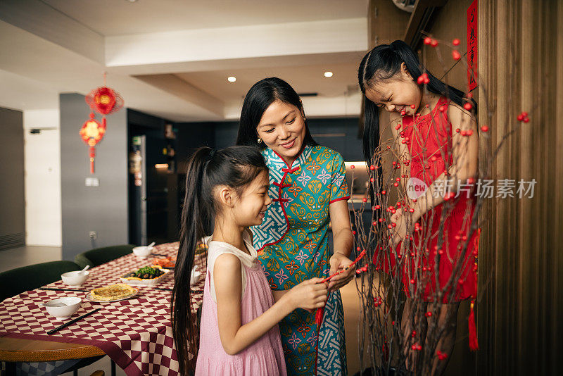 一位中国母亲和她的女儿们正在为中国新年制作装饰品