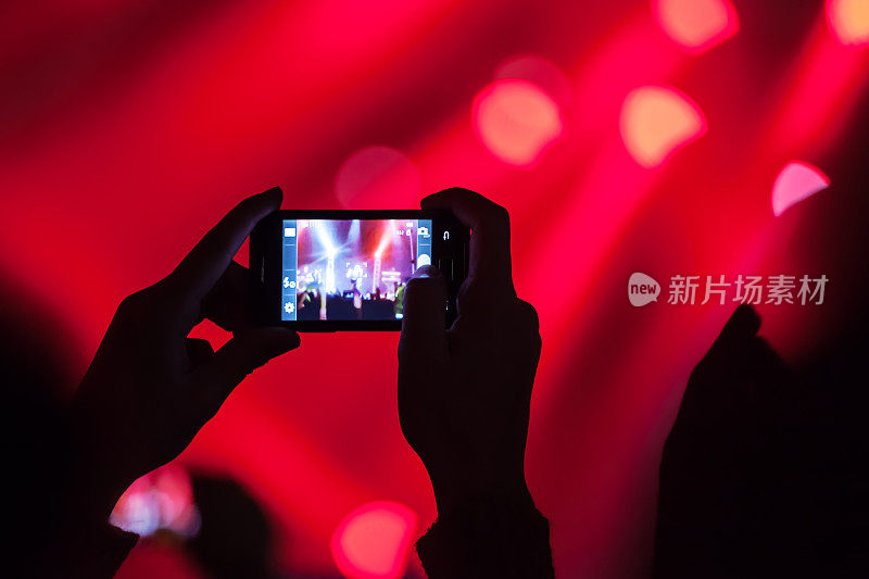 人们在音乐会拍摄视频或照片。