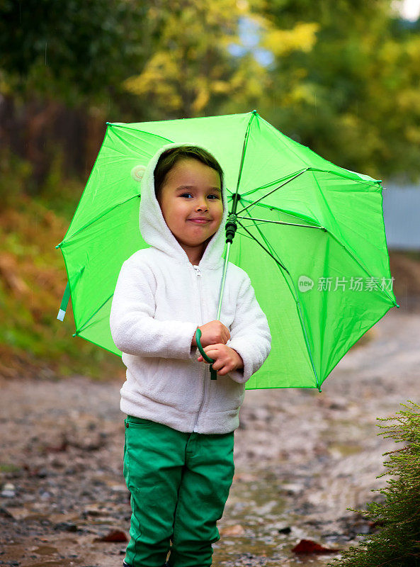 小女孩撑着伞在雨中