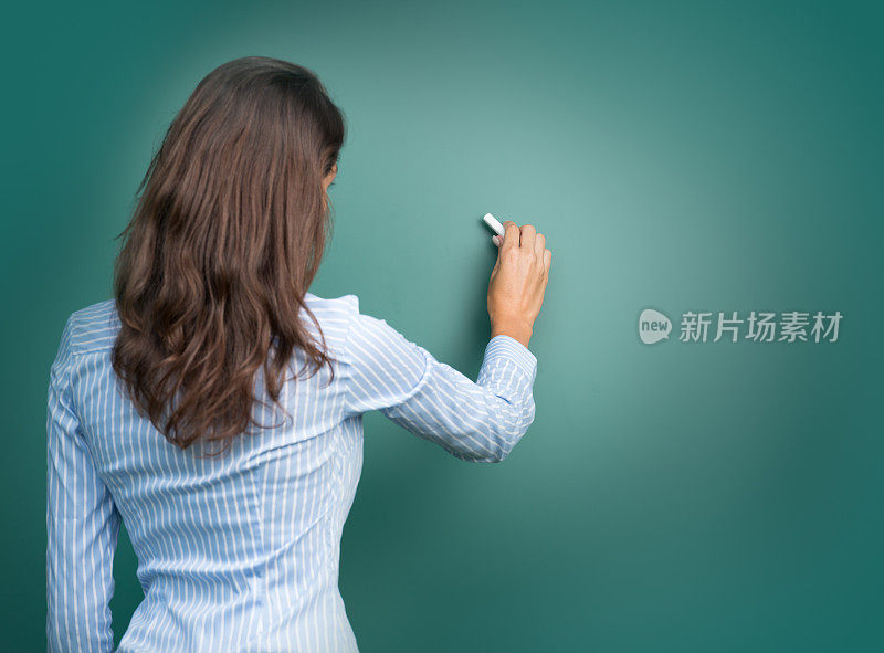 美丽的女人在黑板上写字