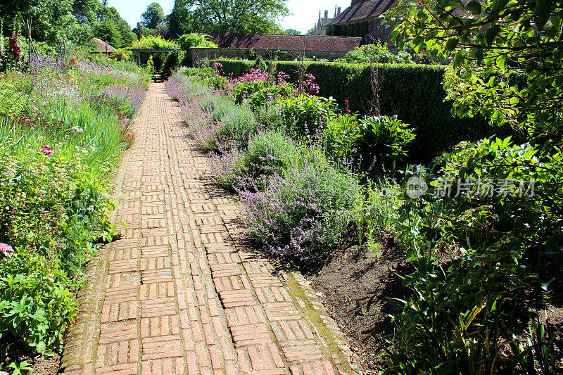 红砖砌成的小径，两旁点缀着花草，村舍花园