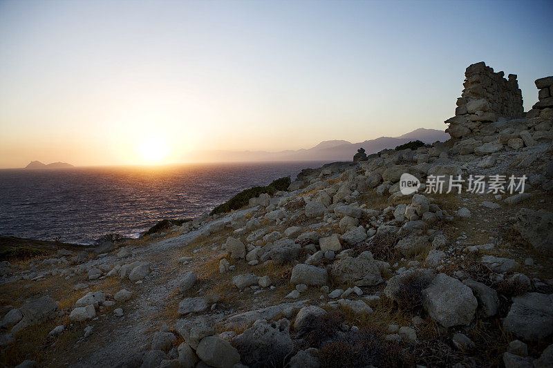 地中海和克里特岛的岩石海滩上的日落