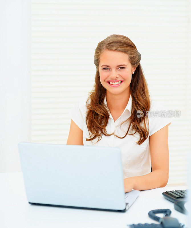 一个年轻漂亮的女人在用笔记本电脑工作