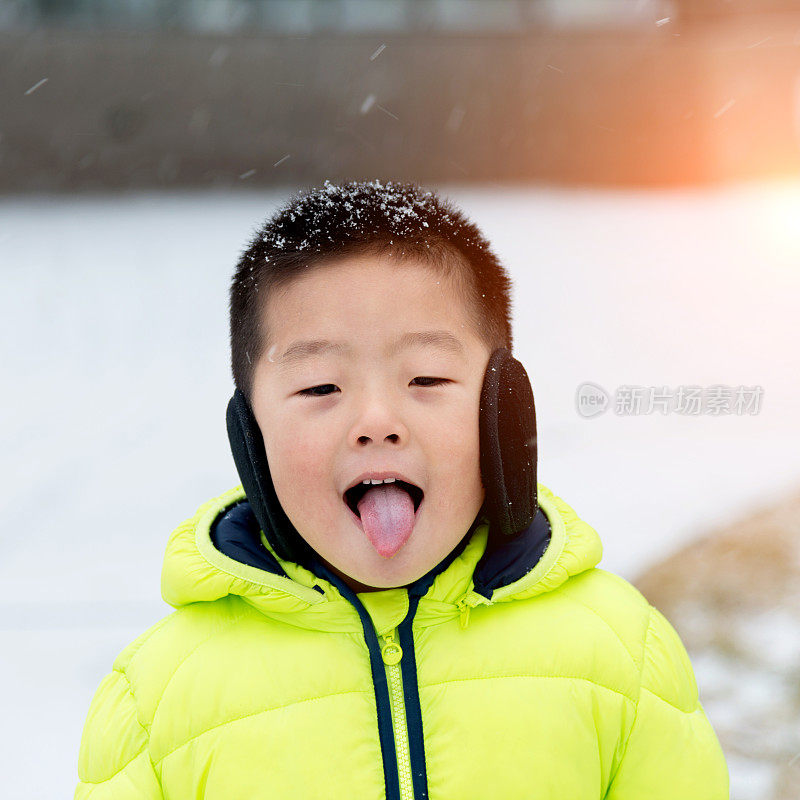 一个亚洲男孩在雪地里玩