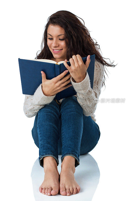 年轻女子坐着漫不经心地读着一本书