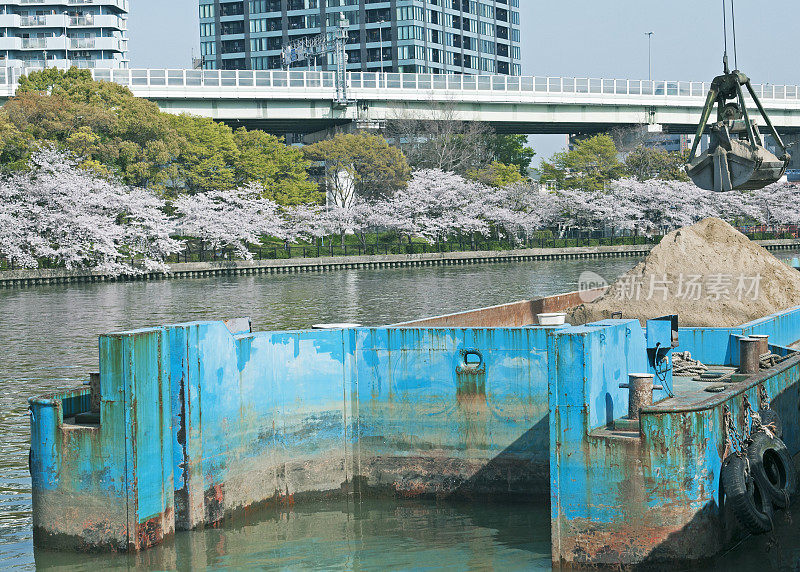 起重机在日本水泥厂从驳船上清除沙子