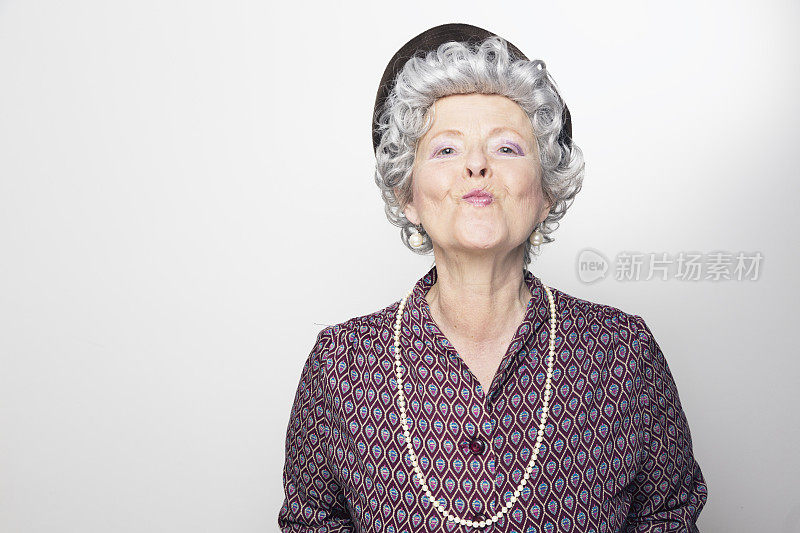 戴着帽子和珍珠接吻的古怪的老女人