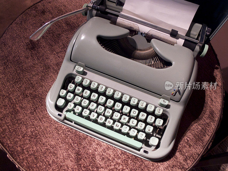 桌上放着一台灰色的老式手动打字机