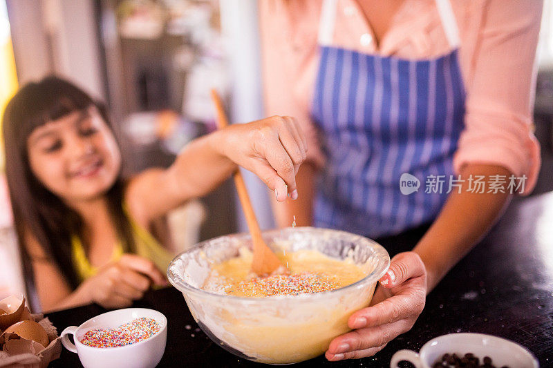 小女孩正在往蛋糕粉里撒糖屑