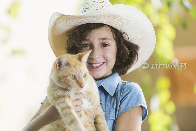 快乐的小女孩抱着一只橙色的猫