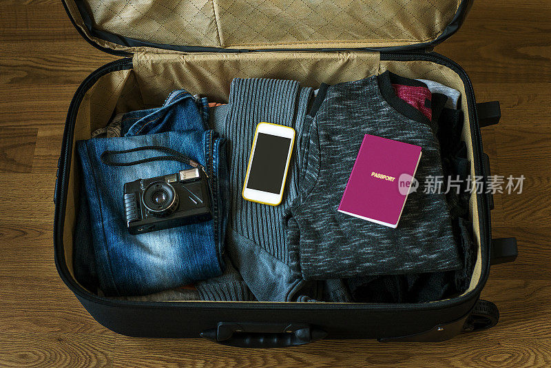 手提箱的高角度视图，带有相机，手机，护照