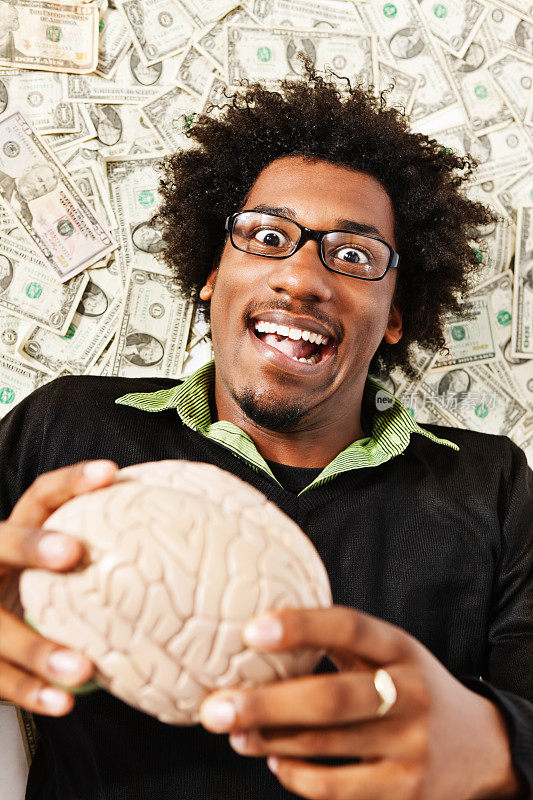 拿着模型大脑躺在美元上的滑稽极客