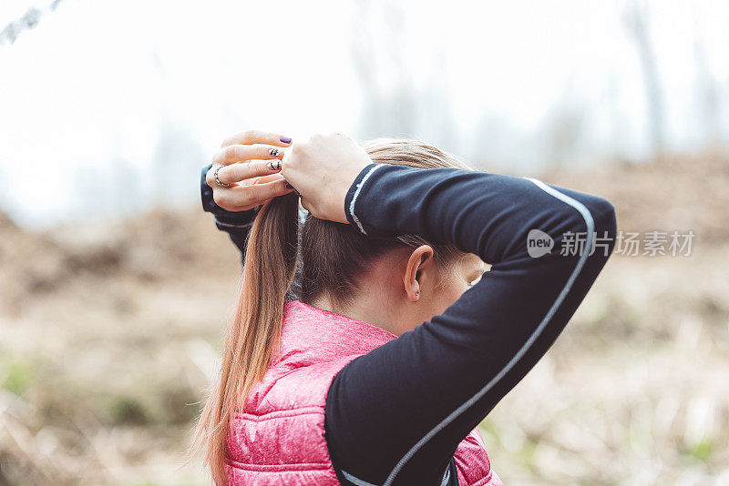 迷人的年轻女孩做马尾辫