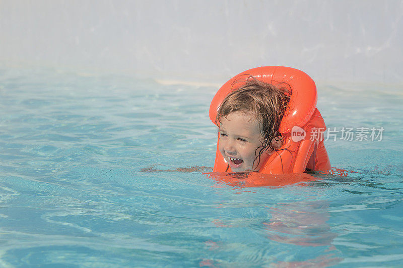 这个女孩在水上公园的游泳池里洗澡。大海的其余部分。