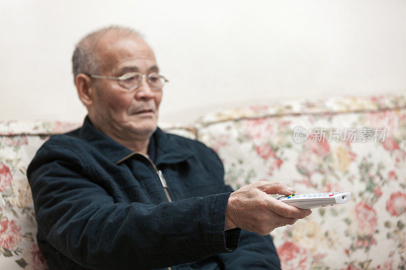 亚洲老人使用电视遥控器