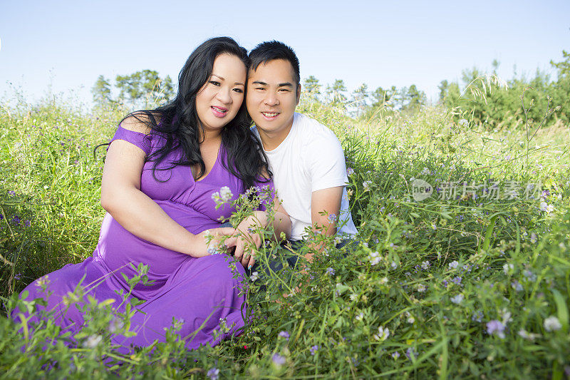 微笑的亚洲夫妇肖像在野外