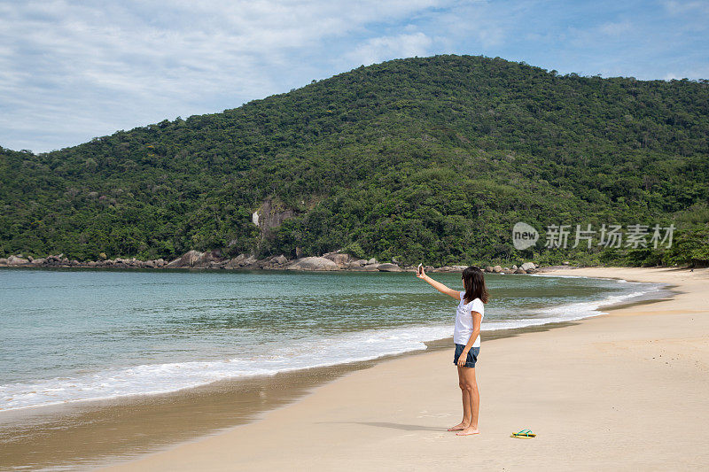 美女在荒芜的海滩上自拍。