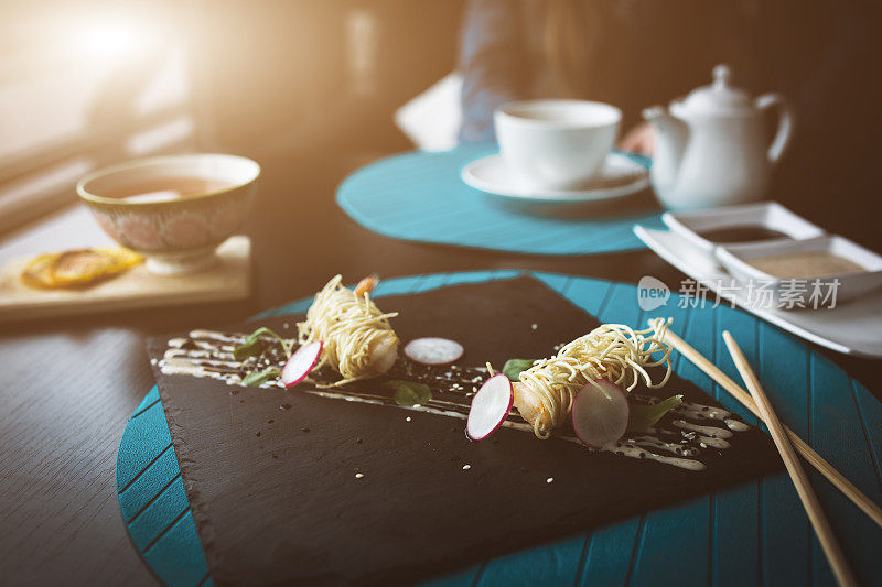 黑盘酱面虎虾。亚洲食品的概念。人们的背景在餐馆的地方与木桌。耀斑复制空间的文字，设计