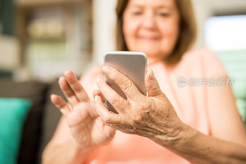 一位年长的成年女性在触摸手机屏幕