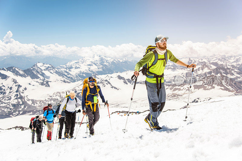 一群登山运动员爬上了一座白雪皑皑的山峰