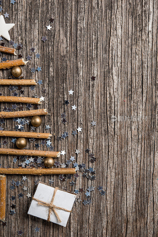 一棵由树枝和金色珍珠组成的圣诞树，在质朴的木质背景上留出文字空间