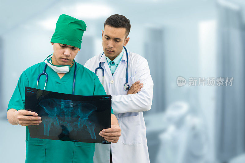 外科医生和医生在看x光片。